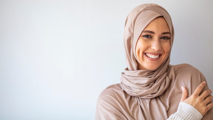 Islamic woman smiling at camera.