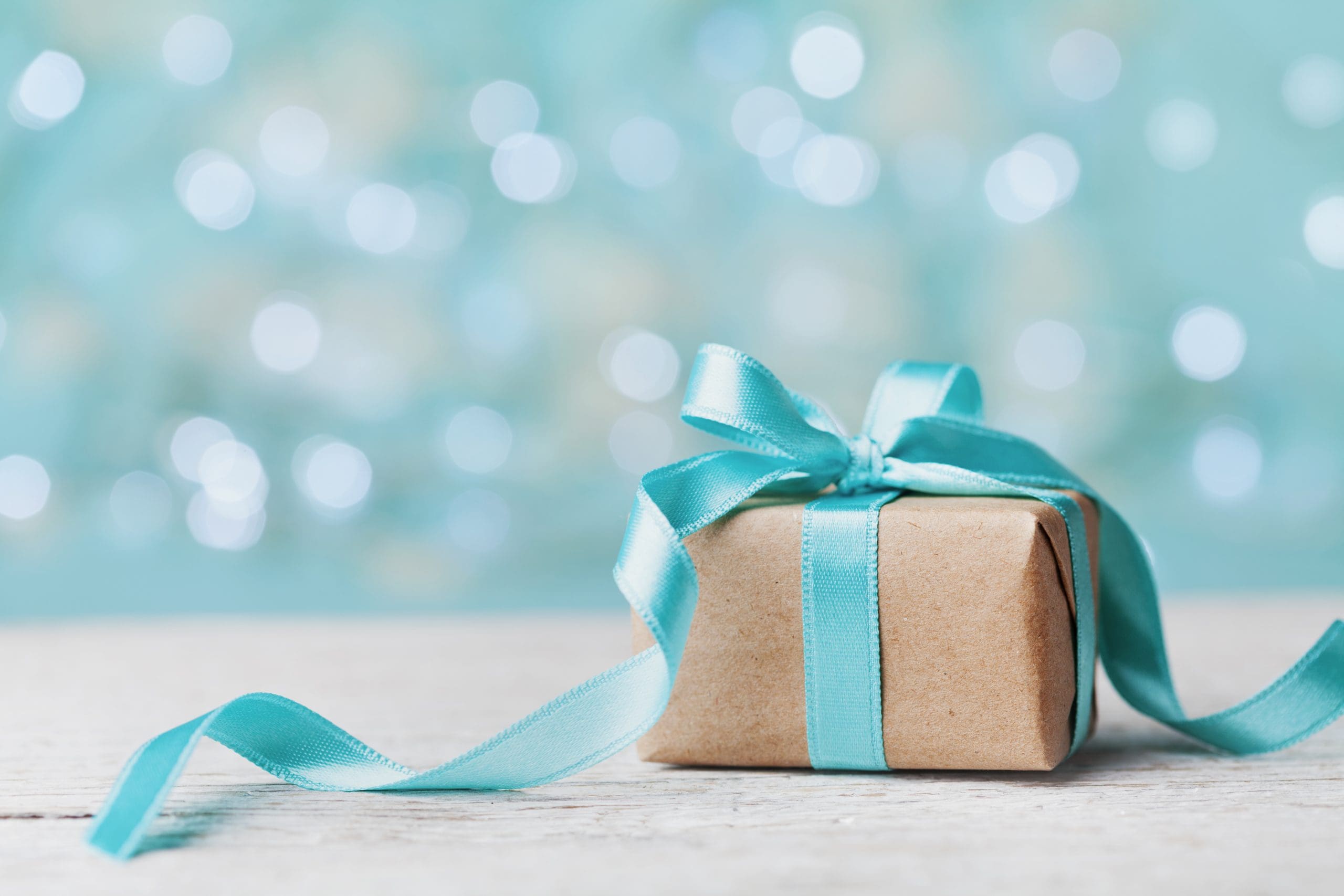 A brown present wrapped in blue ribbon.